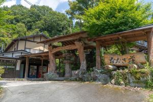 ein Holzgebäude mit Schriftzeichen in der Unterkunft 阿蘇扇温泉 おおぎ荘 in Minamioguni