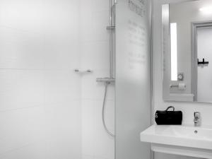 a white bathroom with a sink and a mirror at Hôtel ibis Styles Clermont-Ferrand Gare in Clermont-Ferrand +46 photos