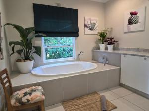 a large bath tub in a bathroom with a window at Milner Manor in Grahamstown +52 photos
