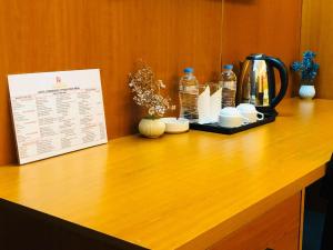 a counter with a coffee maker and a menu at Hotel Rosewood Uttara in Kāmarpāra