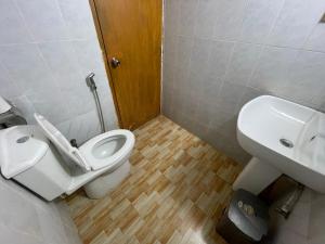 a bathroom with a toilet and a sink at Hotel Rosewood Uttara in Kāmarpāra