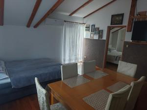 a bedroom with a table and a bed and a table and chairs at Apartman Lara in Krapina