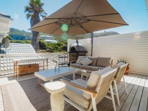 a patio with a table and a couch and an umbrella at Sun and Sea Glentana in Glentana
