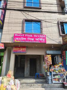 a store with a pink sign on the front of a building at Hotel Pink Orchid in Chittagong