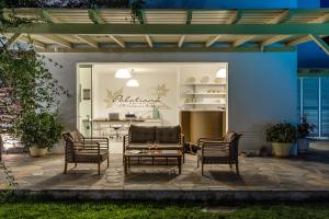 a patio with chairs and a couch and a table at Palatiana Agriturismo-Philoxenia Cottages Retreat in Galini