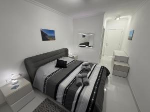 a bedroom with a large bed in a white room at Welcome Apartment 13 in Għajn Melel