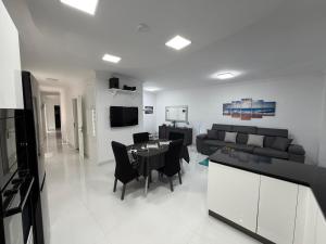 a living room with a couch and a table and chairs at Welcome Apartment 13 in Għajn Melel