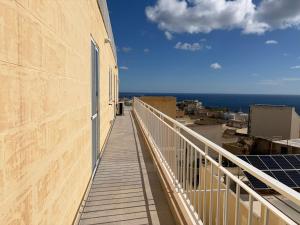 a balcony of a building with a view of the ocean at Welcome Apartment 13 in Għajn Melel +6 photos