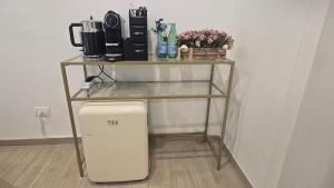 a glass table with a shelf above a small refrigerator at Centrale Suites in Brindisi