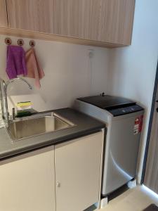 a small kitchen with a sink and a stove at Sematan Roxy Beach Apartment in Sematan +5 photos
