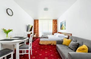 a bedroom with a couch and a bed and a table at M-Apartamenty in Kołobrzeg