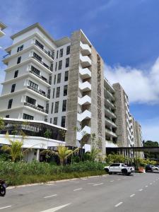 a white car parked in front of a building at Sematan Roxy Beach Apartment in Sematan