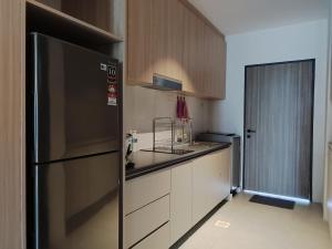 a kitchen with a stainless steel refrigerator and white cabinets at Sematan Roxy Beach Apartment in Sematan
