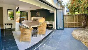 a bedroom with a bed and chairs on a patio at Vida Nova Retreat in Hout Bay