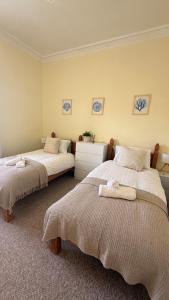 a bedroom with two beds with towels on them at Vistamar Dunoon in Dunoon
