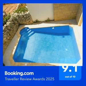 a large blue swimming pool in a yard at 14, Triq Il Mithna in Qala +10 photos