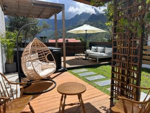 a patio with a swing and a table and chairs at Le djebel in Cilaos