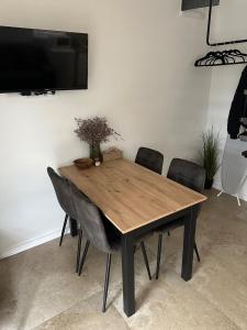 a wooden table with chairs and a television on a wall at KörösPartOn in Békésszentandrás