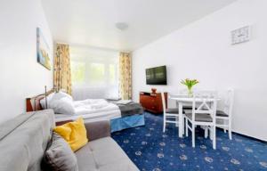 a hotel room with a bed and a table and chairs at M-Apartamenty in Kołobrzeg
