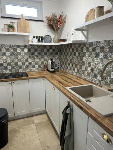 a kitchen with white cabinets and a sink at KörösPartOn in Békésszentandrás