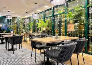 a restaurant with tables and chairs and plants on the wall at M-Apartamenty in Kołobrzeg