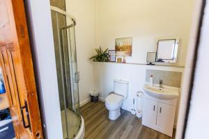 a bathroom with a toilet and a sink at Modern Barn Conversion in Brackley