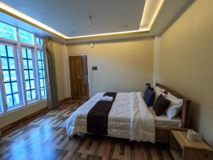 a bedroom with a bed with white sheets and pillows at Taleries Stays in Dirang Dzong