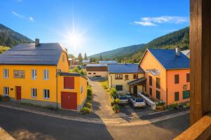 a group of houses in a village with mountains in the background at L'HappyMijoux in Mijoux