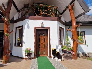 a cat sitting at the door of a house at Bylew Zacisze in Licheń Stary