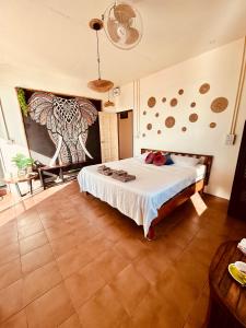 a bedroom with a bed and a painting on the wall at Tchin tchin Guesthouse in Ko Chang