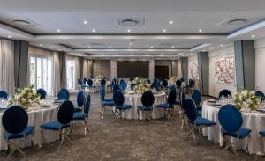 a banquet hall with tables and chairs and a screen at Hotel Cardoso in Maputo +136 photos