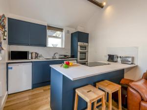 a kitchen with blue cabinets and a counter top at The Gables Studio in Keswick