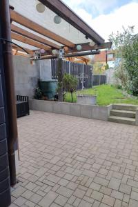 a patio with a wooden pergola and a yard at Ferienwohnung an der Klosterkirche in Nienburg Saale in Nienburg
