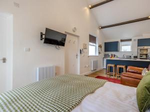 a bedroom with a bed and a tv on the wall at The Gables Studio in Keswick +3 photos