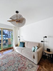 a living room with a couch and a chandelier at Hello Menton in Menton