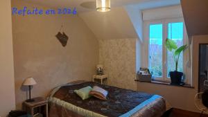 a bedroom with a bed and a window at Au Moulin de la Tour in La Malmaison