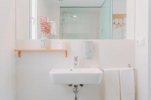 a white bathroom with a sink and a mirror at Hostal La Isla in Carboneras +69 photos
