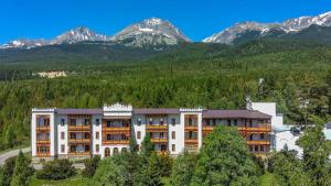 an apartment building with mountains in the background at Kúpeľný dom GERLACH in Vysoké Tatry