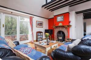 a living room with a couch and a fireplace at Spout House Studio in Boldre