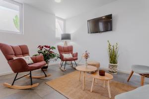 a living room with chairs and a tv on a wall at Hostal La Isla in Carboneras
