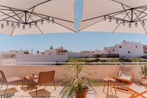 a patio with chairs and tables on a roof at Hostal La Isla in Carboneras