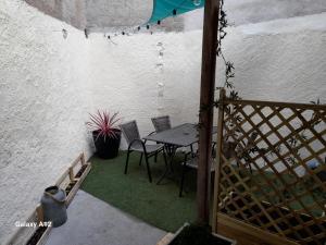 a patio with a table and chairs next to a wall at Maison centre ville Bourgueil in Bourgueil
