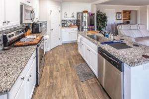 a kitchen with white cabinets and wooden floors at Hideaway Getaway in Statham