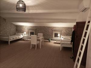 a man standing in a room with beds and tables at Les 3 Platanes in Conilhac-Corbières