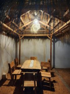 ein Holztisch und Stühle in einem Raum mit einer Decke in der Unterkunft Sassi Villa in Arkou