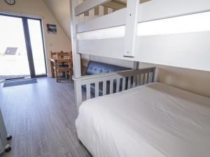 a bedroom with bunk beds and a dining room at Cabin 5 Eargail in Gortahork