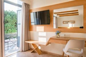 a room with a desk with a tv and a window at Panellinion Luxury Rooms in Kalamata