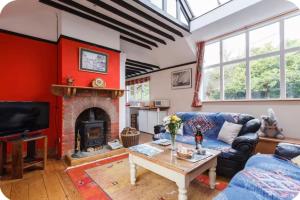 a living room with a couch and a fireplace at Spout House Studio in Boldre