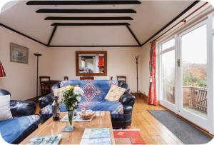 a living room with a blue couch and a table at Spout House Studio in Boldre +32 photos