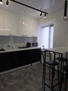a kitchen with white cabinets and a table and chairs at Апартаменты возле отеля Украина in Chernihiv +9 photos